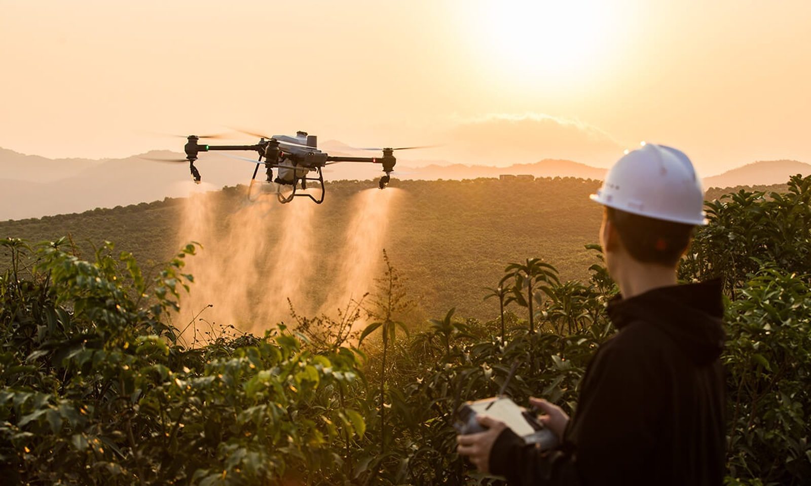 A field operator flying an enterprise drone at sunset